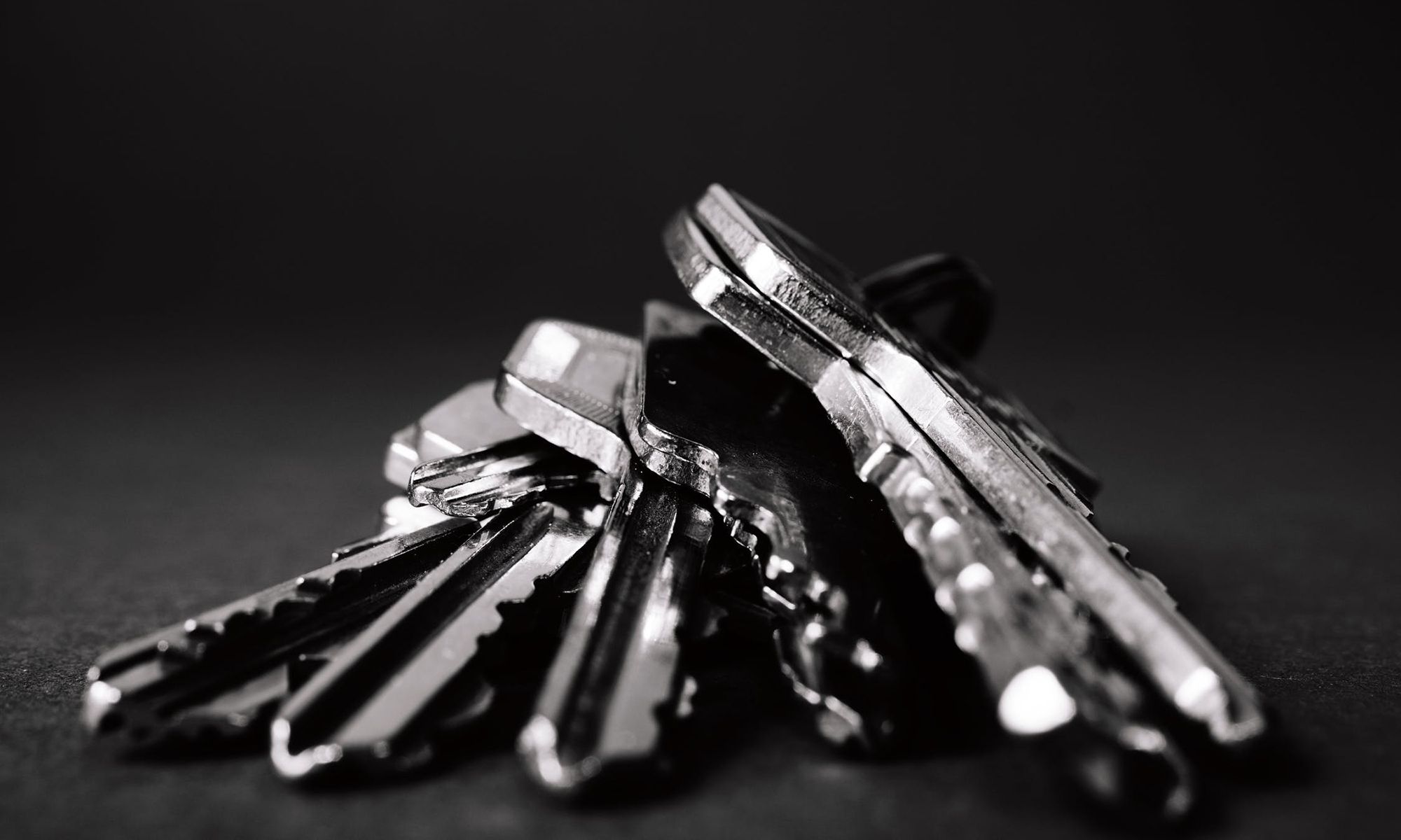 Close-up of a stack of metallic keys on a dark background, representing locksmith services and emergency key solutions.